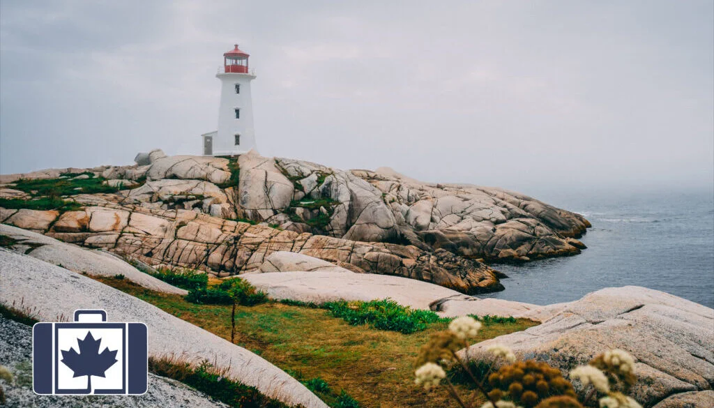 Essential Health and Safety Tips for Visitors to Canada VisitorsInsurance.ca A photograph of a red capped lighthouse at Peggy's Cove surrounded by rugged coastal rocks under a gloomy sky.