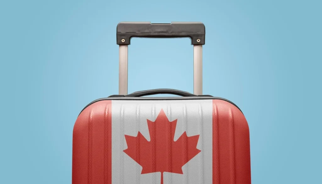 Travel suitcase with a Canadian flag design symbolizing visitors traveling to Canada and preparing for their trip